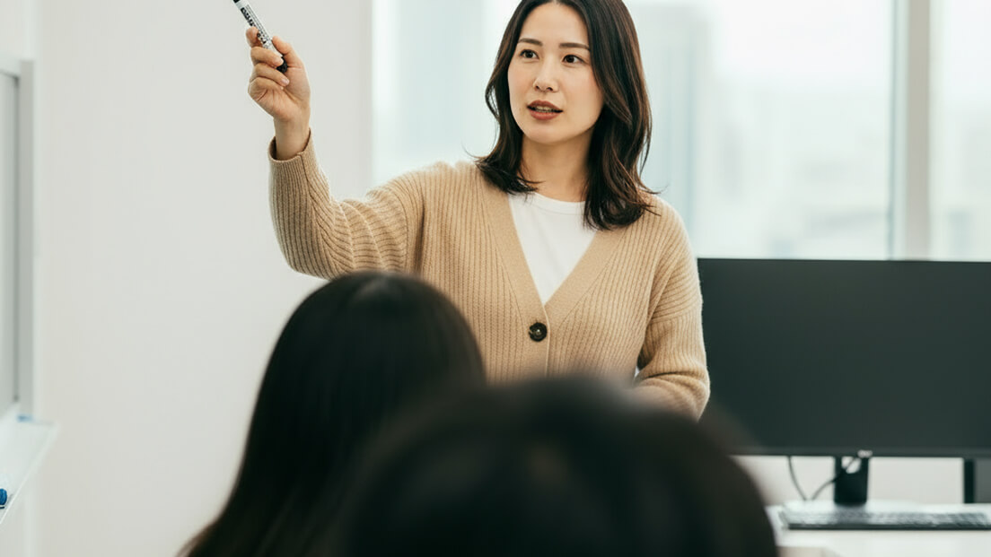 女性がホワイトボードを指し示しながら説明している様子
