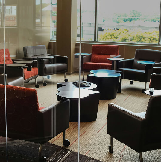 ガラス越しに見えるラウンジスペースの椅子とテーブルの配置